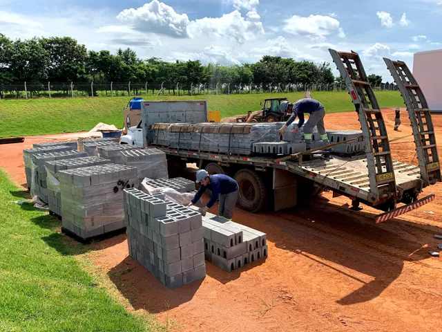 Caminhão e lotes de produtos de concreto durante o fornecimento para uma obra
